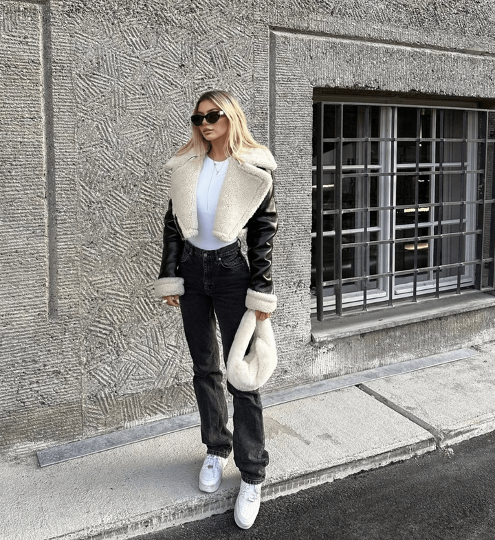 Stylish women's leather jacket with a cozy faux fur collar, perfect warm outerwear for cold winter days.