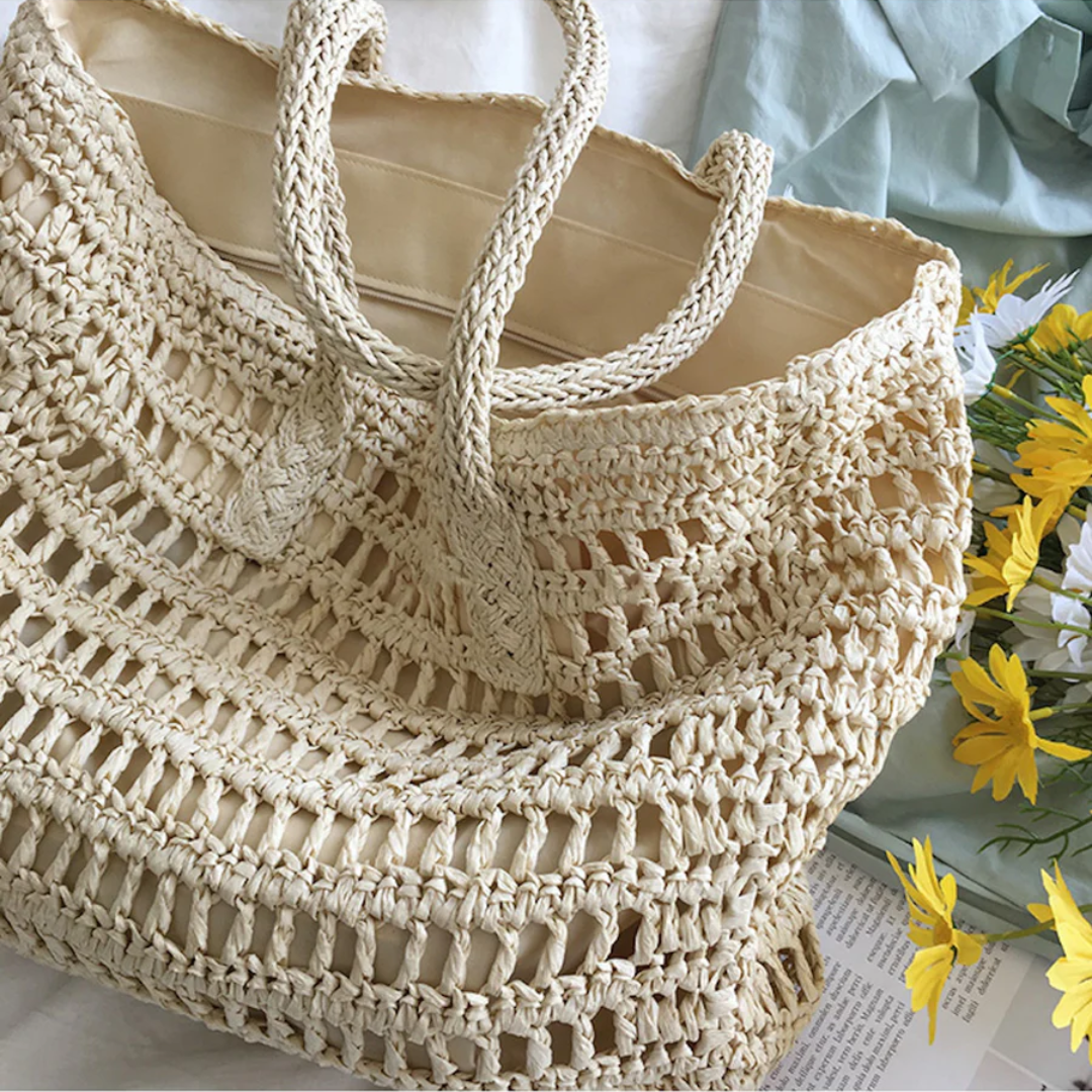 Elegant women's woven straw beach tote bag with strong handles, ideal for summer fashion.