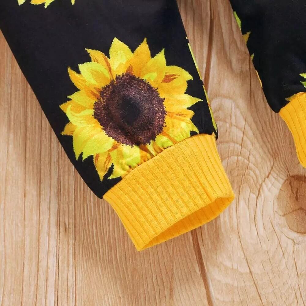 Detail of soft fabric and stitching on a baby girl's long-sleeve sunflower 2-piece fall outfit.