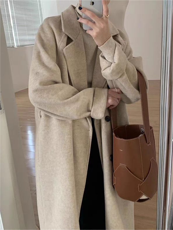 Classic women's winter coat, featuring a flattering belted design, oversized fit, and chic lapel collar. Stylish outerwear.