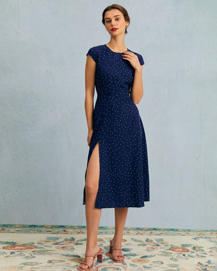 Navy blue polka dot midi dress with elegant cut-outs and cap sleeves, perfect for office or day-to-night wear.