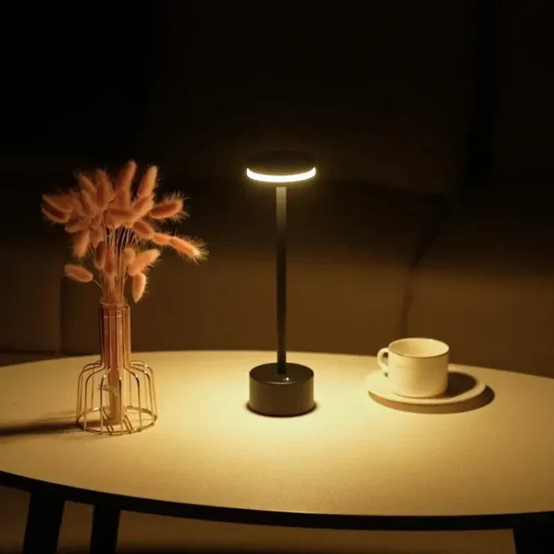 Minimalist rechargeable LED table lamp, dimmable with a touch, enhancing home decor with soft light.