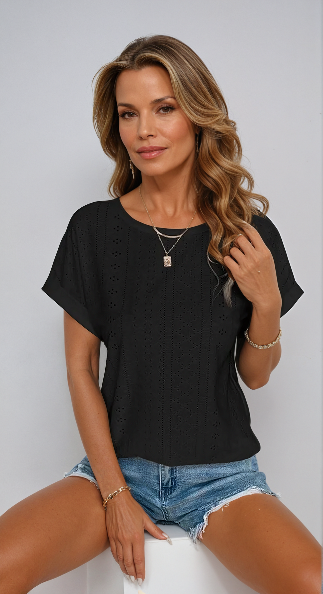 Fashionable ladies' short sleeve top, eyelet detail, relaxed fit, versatile for casual summer wear.