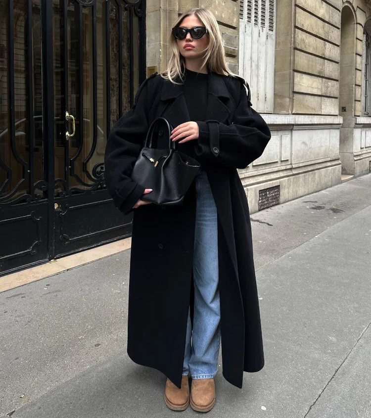 Elegant women's double-breasted classic black trench coat. Stylish long outerwear for seasonal fashion.