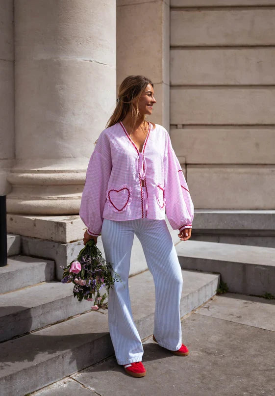 Close-up of a women's long sleeve tie-front blouse, highlighting the stylish ruffles and puff sleeve detail.