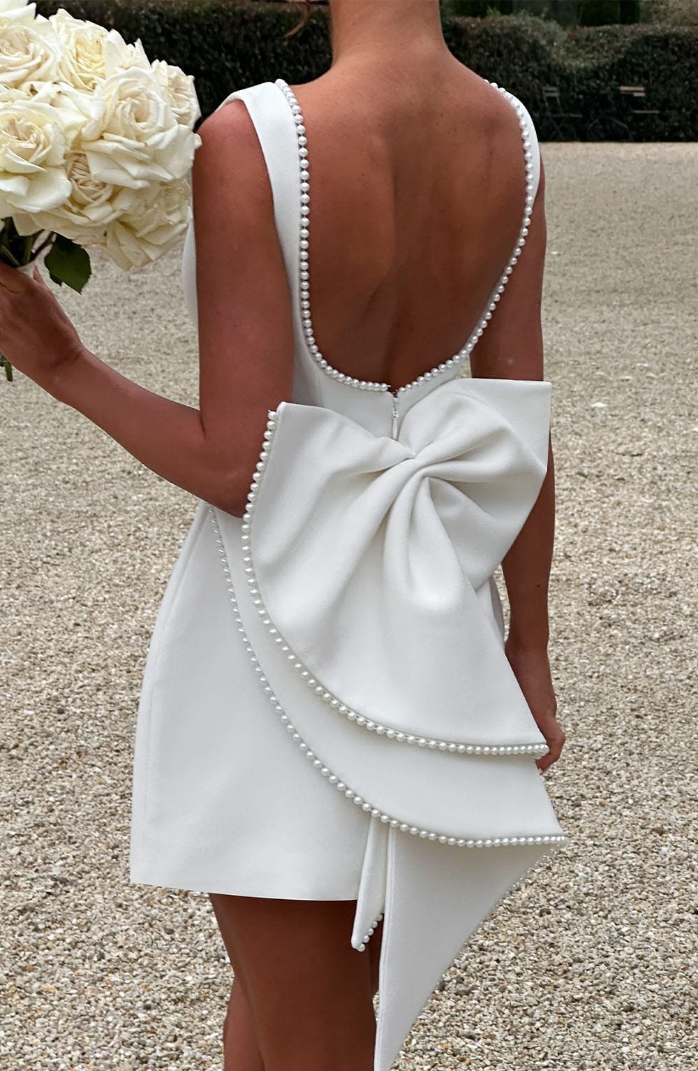 Chic women's boat neck mini dress, sleeveless, with an eye-catching back bow, great for special events.