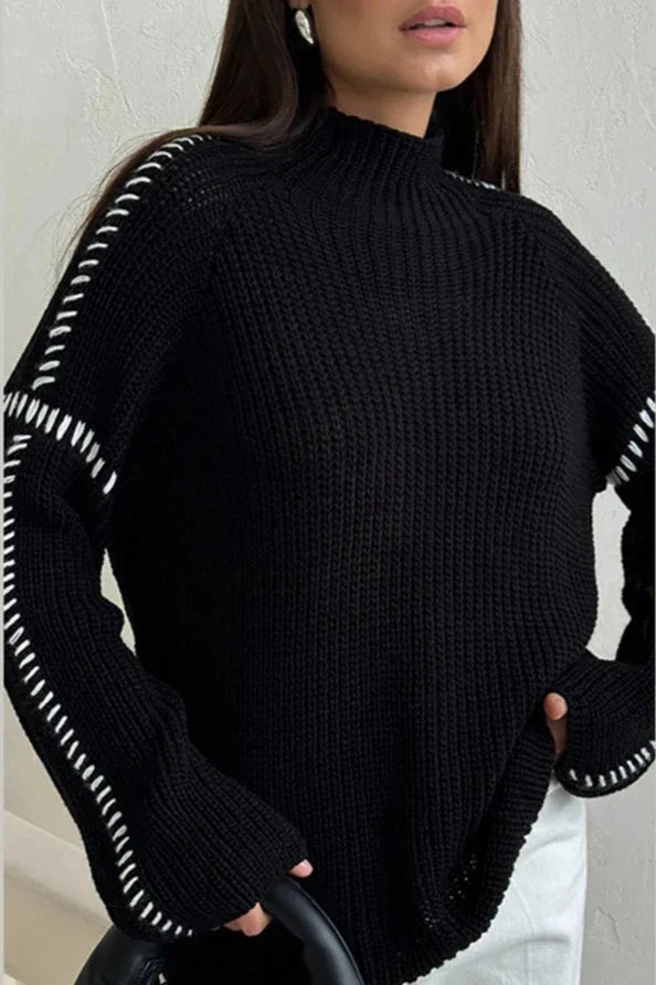 Women's chunky knit oversized mock neck jumper. Features a distinctive contrast stitch, ideal for cozy winter style.