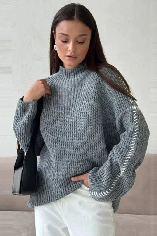 Soft, oversized women's knit sweater with a cozy mock neck and stylish contrast stitch. Essential winter fashion.