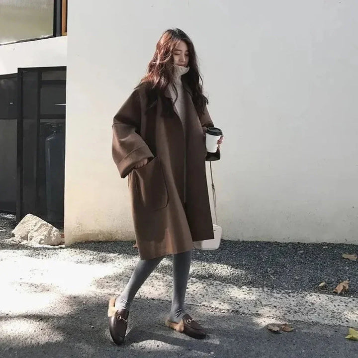 Chic women's long black trench coat, an essential oversized outerwear piece for sophisticated fall style.