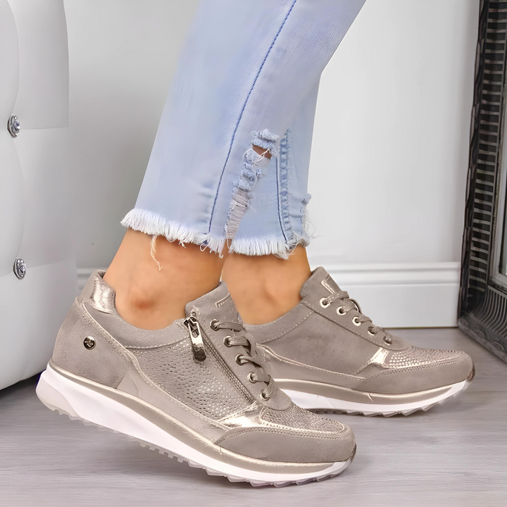 Close-up of women's wedge sneakers, durable material, lace-up front, wide toe design for support.